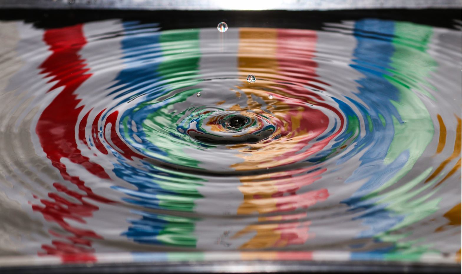 Drip and ripples on water in colorful bowl. Photo by Jordan McDonald on Unsplash.